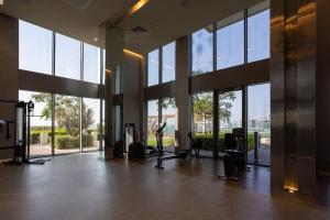 een fitnessruimte met een grote kamer met grote ramen bij Waves Holiday Homes - Sea View Luxury 3 Bedroom Apartment With Balcony in Dubai