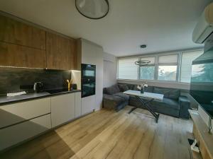 cocina y sala de estar con sofá y mesa en Чудесен нов апартамент Илинден, en Varna