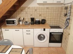 uma cozinha com uma máquina de lavar roupa e um micro-ondas em La Molette - 4 personnes em Saint-Julien-Molin-Molette