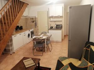 a kitchen with a table and a kitchen with a staircase at La Molette - 4 personnes in Saint-Julien-Molin-Molette