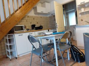 uma cozinha com mesa e cadeiras num quarto em La Molette - 4 personnes em Saint-Julien-Molin-Molette
