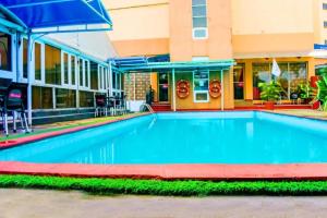 une piscine en face d'un bâtiment dans l'établissement Golden Tulip Hotel Port Harcourt -GTPH, à Port Harcourt