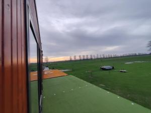 een uitzicht op een veld vanuit een treinraam bij Tiny House Betuwe in Tricht