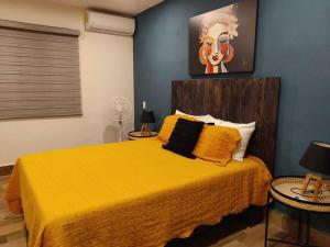a bedroom with a bed with a yellow blanket at Hermosa casa para conocer León in León