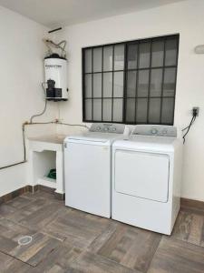 uma máquina de lavar e secar roupa branca num quarto em Hermosa casa para conocer León em León
