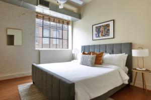 a bedroom with a large bed and a window at Constance Lofts by Black Swan in New Orleans