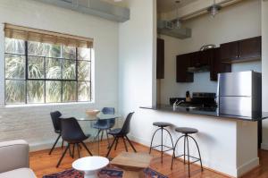 a kitchen with a counter and chairs and a table at Constance Lofts by Black Swan in New Orleans
