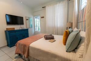 Schlafzimmer mit einem Bett und einem TV an der Wand in der Unterkunft Casa Piña Suave #2 Jungle seclusion close to ocean in Rincon