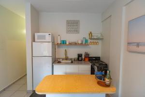 eine kleine Küche mit einem weißen Kühlschrank und einem Tisch in der Unterkunft Casa Piña Suave #2 Jungle seclusion close to ocean in Rincon