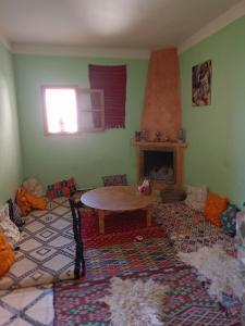 salon ze stołem i kominkiem w obiekcie Gite Skoura w mieście Caïd Bou Malla
