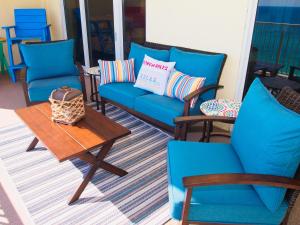 une terrasse couverte avec des chaises bleues et une table basse dans l'établissement Ocean Reef 1102, à Panama City Beach