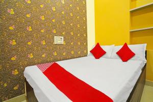 uma cama com almofadas vermelhas num quarto em OYO Flagship Hotel Sigdi & Restaurant em Jaipur