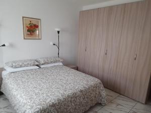 Villa Azzurra في مونفالكوني: غرفة نوم بسرير وخزانة خشبية