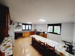 a room with a kitchen with tables and windows at Casa Verde. in Villaviciosa