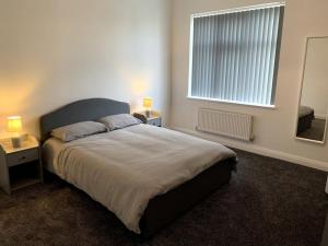a bedroom with a large bed and a window at New large 2 bedroom apartment with private parking 