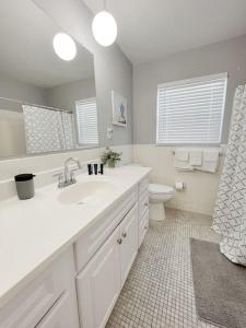 a white bathroom with a sink and a toilet at Beautiful Waterfront Beach Condo With Dock in St Pete Beach