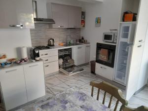uma cozinha com armários brancos e um forno com placa de fogão em Villa Azzurra em Monfalcone