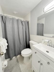 a white bathroom with a toilet and a sink at Beautiful Waterfront Beach Condo With Dock in St Pete Beach