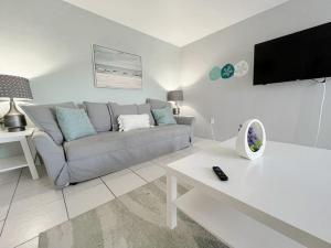 a living room with a couch and a tv at Beautiful Waterfront Beach Condo With Dock in St Pete Beach