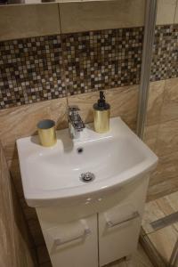 a bathroom sink with two cups on top of it at AS apartmán sever in Košice