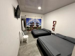 um quarto com 2 camas, uma televisão e uma cadeira em JAMJALI HOTEL ARMERO GUAYABAL (PISCINA-COCINA LIBRE) em Guayabal