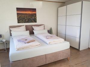 - une chambre avec un lit et 2 serviettes dans l'établissement Ferienwohnung Zur Alten Gärtnerei, à Hürtgenwald