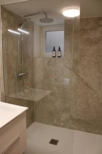 La salle de bains est pourvue d'une douche avec une porte en verre. dans l'établissement Cozy aux 3 frontières, à Sierck-les-Bains