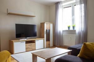 sala de estar con TV de pantalla plana en un centro de entretenimiento de madera en AS apartmán sever, en Košice
