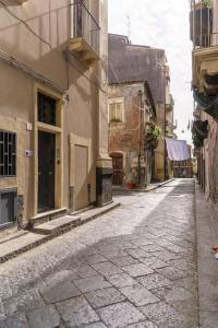una calle vacía en un callejón con edificios en Appartamento Domus Lavica en Catania