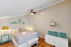 a bedroom with a bed and a ceiling fan at Driftwood Villa - 267 in Edisto Island