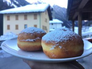 dos donuts en un plato en una mesa en Agritur Ruatti, en Rabbi