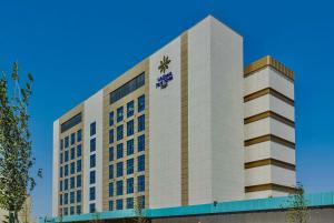 Un grand bâtiment blanc avec une horloge. dans l'établissement Hilton Garden Inn Samarkand Sogd, à Samarcande