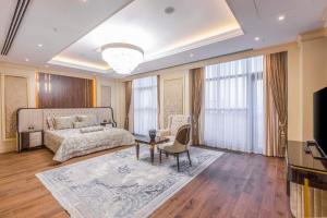 een slaapkamer met een bed en een tv en een bank bij Hilton Garden Inn Samarkand Sogd in Samarkand