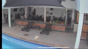 a swimming pool with two chairs and an umbrella at JAMJALI HOTEL ARMERO GUAYABAL (PISCINA-COCINA LIBRE) in Guayabal