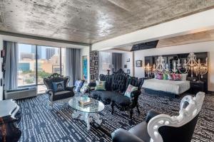 a living room with a bed and a couch and chairs at Lorenzo Hotel Dallas, Tapestry Collection by Hilton in Dallas