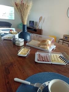 una mesa de madera con platos de comida. en Asas da Maré Pousada en Bragança