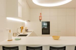 a kitchen with white cabinets and a white counter top at Casa Rua da Fonte - Modern & Relax (Bay View) in Ponta Delgada +24 photos