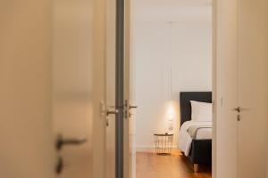 a bedroom with a bed and a door leading into a room at Casa Rua da Fonte - Modern & Relax (Bay View) in Ponta Delgada