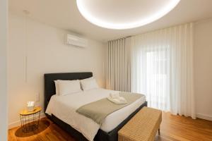 a bedroom with a bed and a large window at Casa Rua da Fonte - Modern & Relax (Bay View) in Ponta Delgada