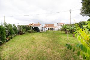 um quintal vazio em frente a uma casa em WelcomeBuddy - São Brás Collection Jacuzzi&Garden em Porto Formoso