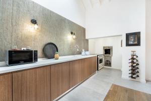 a kitchen with a counter top with a microwave at WelcomeBuddy - São Brás Collection Jacuzzi&Garden in Porto Formoso