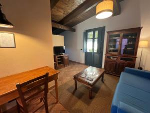 a living room with a table and a blue couch at Le Serre Suites & Apartments in Moncalieri