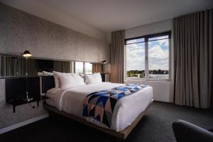 ein Hotelzimmer mit einem großen Bett und einem Fenster in der Unterkunft Hotel Saint George in Marfa
