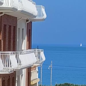 a building with balconies and the ocean in the background at Vento di Mare in Piraino