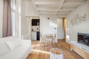 - un salon avec un canapé blanc et une table dans l'établissement Le Natural Fauriel avec terrasse, à Saint-Étienne