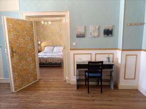 a room with a desk and a bed and a mirror at Domaine de la Moselle in Saint-Maurice-sur-Moselle