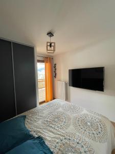 a bedroom with a bed and a flat screen tv at Le Roc in Saint-Jean-d'Aulps