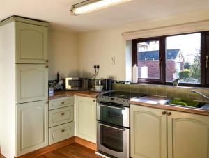 a kitchen with white cabinets and a stove top oven at Our Snug in Riccall