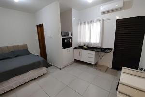 ein Schlafzimmer mit einem Bett und einem Schreibtisch. in der Unterkunft Xavi Studio - Proximo ao Boulevard Shopping, Av Nacoes Unidas e Nuno de Assis. in Bauru