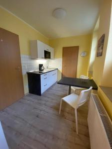 a small kitchen with a table and a white chair at Apartments in der Rostocker Innenstadt in Rostock